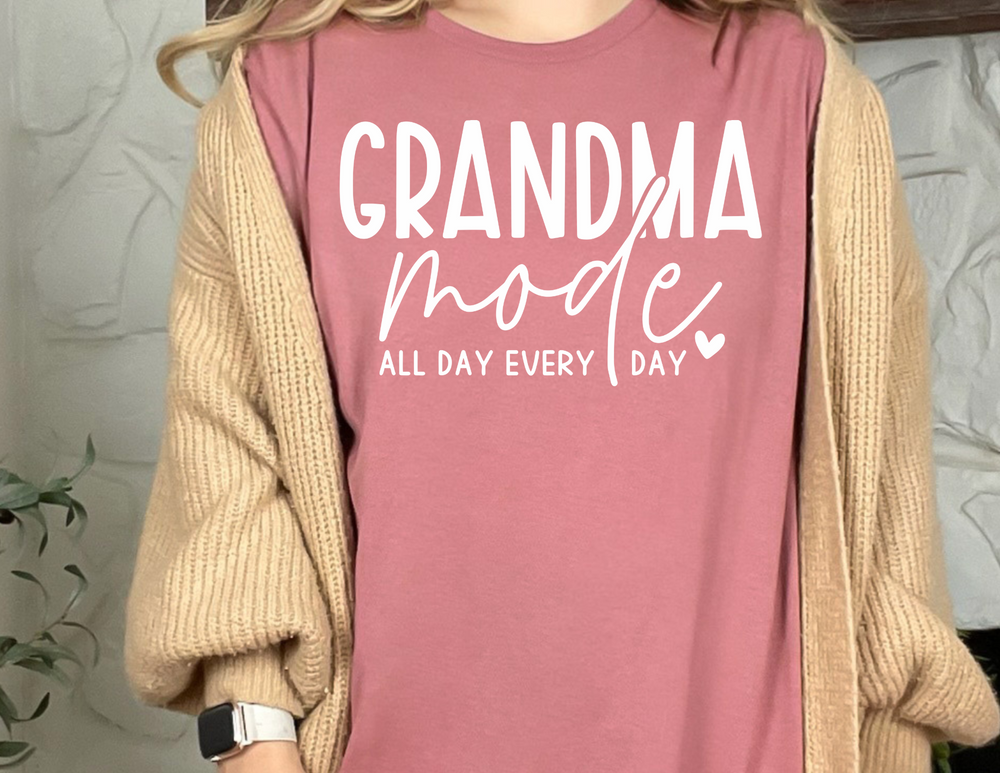 A Grandma Mode Tee, a garment-dyed t-shirt in pink, features ring-spun cotton for coziness. With a relaxed fit and durable stitching, it's a daily essential.