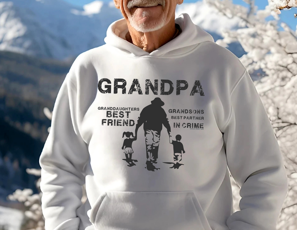 A white Grandpa and Grandkids Hoodie featuring a man and child with snow-covered trees, a kangaroo pocket, and a drawstring hood. Made of cotton and polyester blend for warmth and comfort.