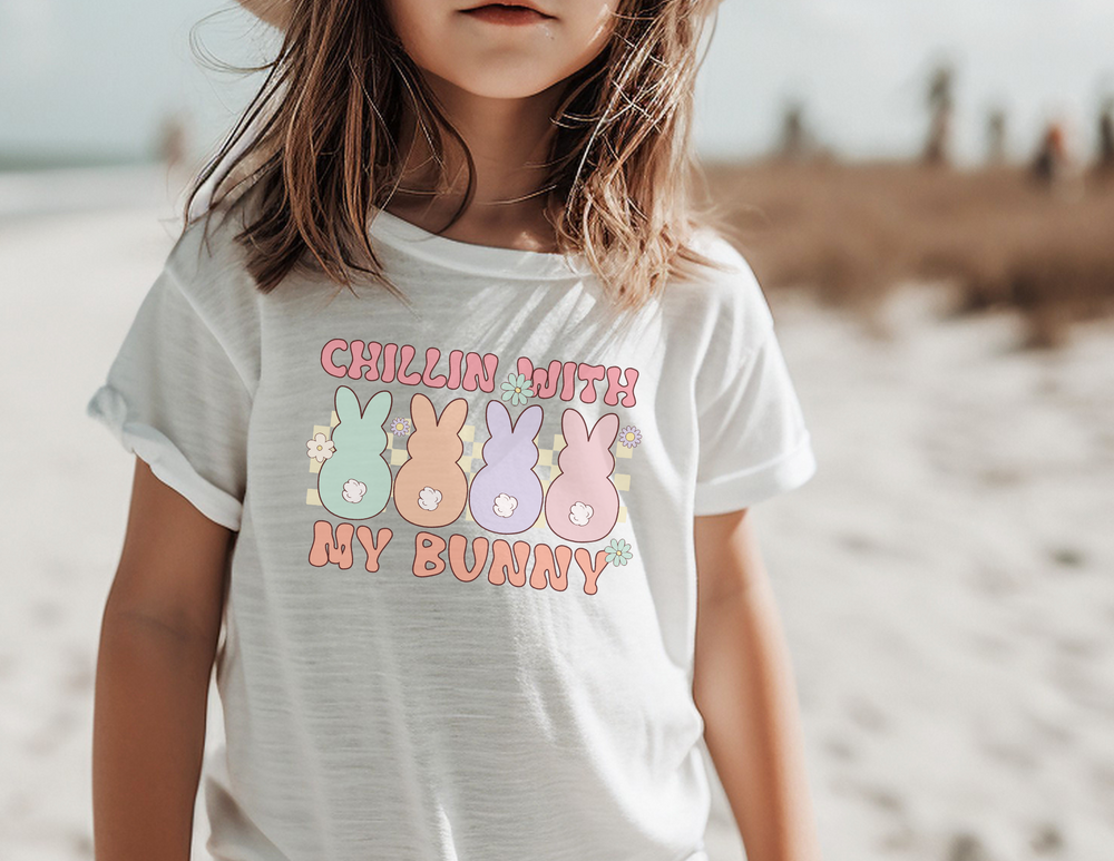 A personalized toddler tee featuring a girl in a white shirt with a hat, surrounded by cartoon bunnies and flowers. Classic fit, 100% Ringspun cotton, 4.5 oz/yd² fabric, durable double-needle collar, sleeve, and bottom hems. From 'Worlds Worst Tees'.