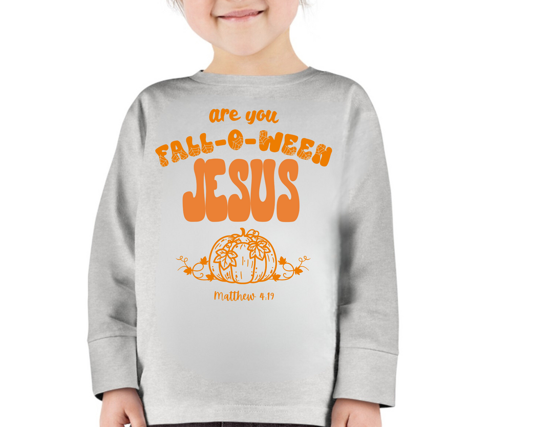 Child wearing a FALL-O-WEEN Jesus themed long-sleeve tee, featuring a pumpkin illustration and Matthew 4:19. Cozy, durable, toddler crew from Worlds Worst Tees.