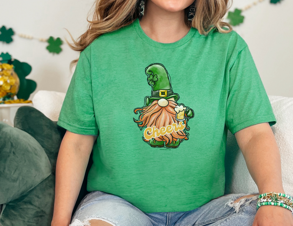 A woman in a green shirt holds a beer, embodying the Cheers Gnome Tee from Worlds Worst Tees. Unisex heavy cotton tee with no side seams, tape on shoulders, and ribbed collar. Classic fit, 100% cotton.