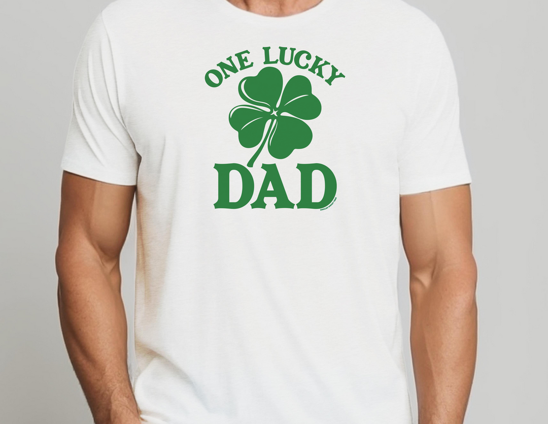 A white tee featuring a green clover, perfect for casual style. Unisex heavy cotton tee with no side seams for comfort. Ribbed knit collar for elasticity and durability. One Lucky Dad Tee from Worlds Worst Tees.