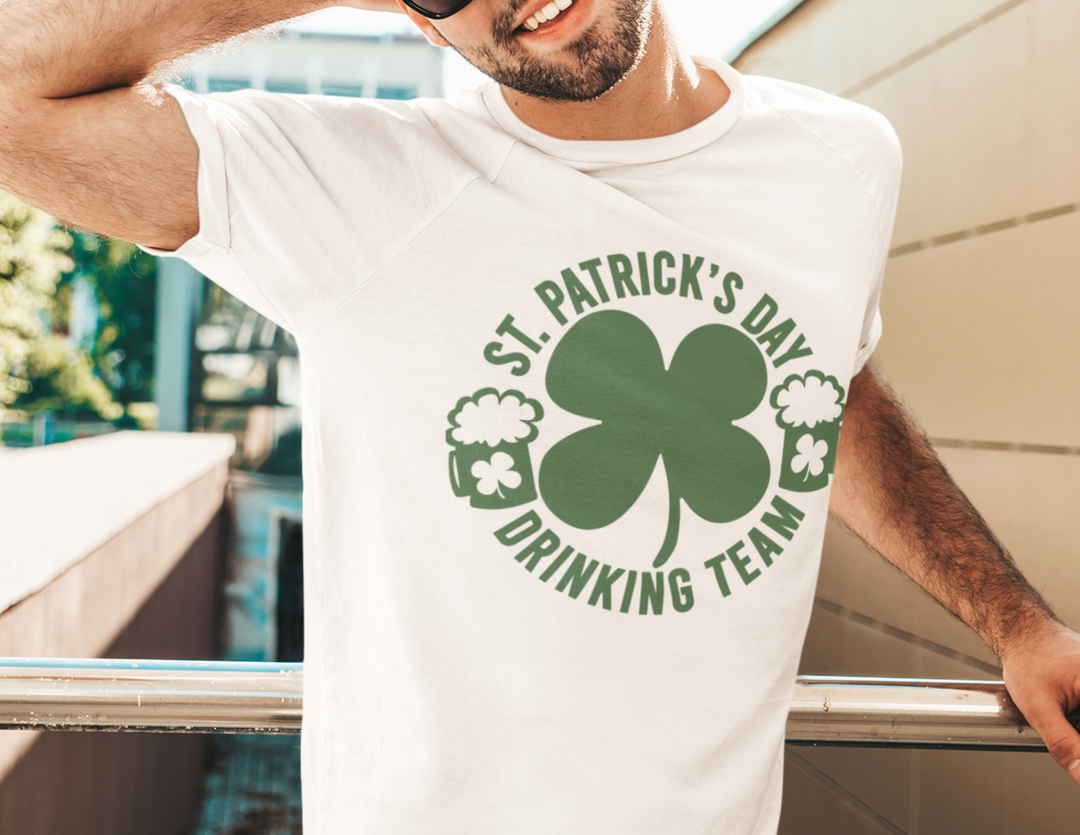 St. Patrick's Day Drinking Team Tee: A man in sunglasses wearing a white shirt with a shamrock design. Premium fit, ribbed collar, 100% cotton, light fabric. Ideal for workouts or casual wear.