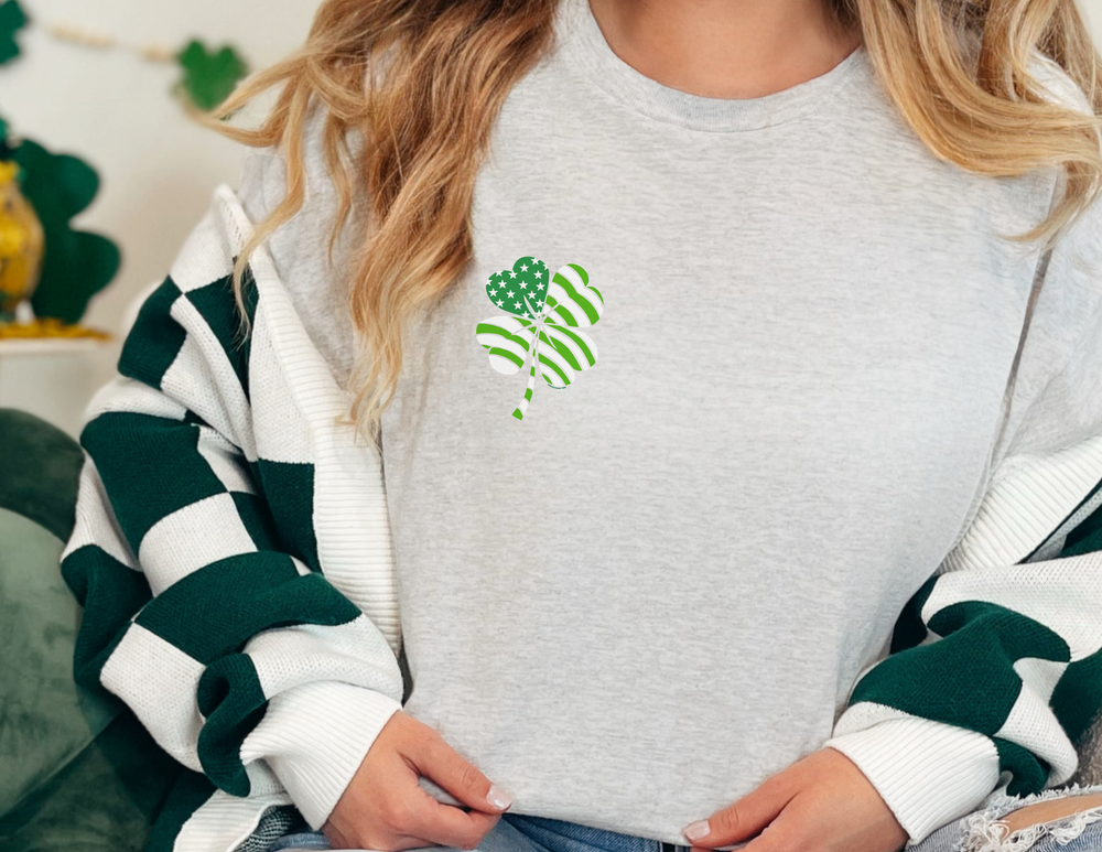 A woman wears a USA Clover Tee, a staple in any wardrobe. Unisex heavy cotton tee with no side seams, tape on shoulders for durability, and ribbed knit collar. Classic fit, 100% cotton.