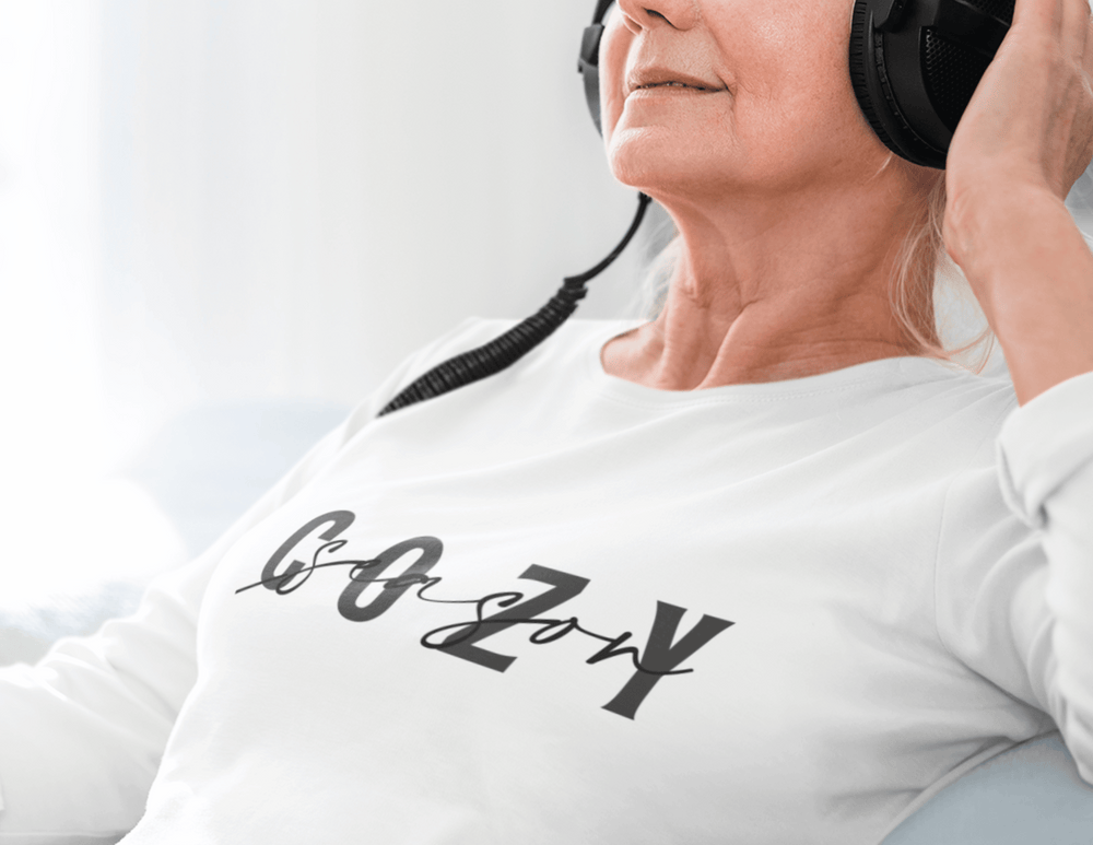A woman wearing headphones in a cozy season long sleeve tee. Unisex, 100% US cotton shirt with ribbed cuffs for a classic fit. Perfect for all-day comfort and style.