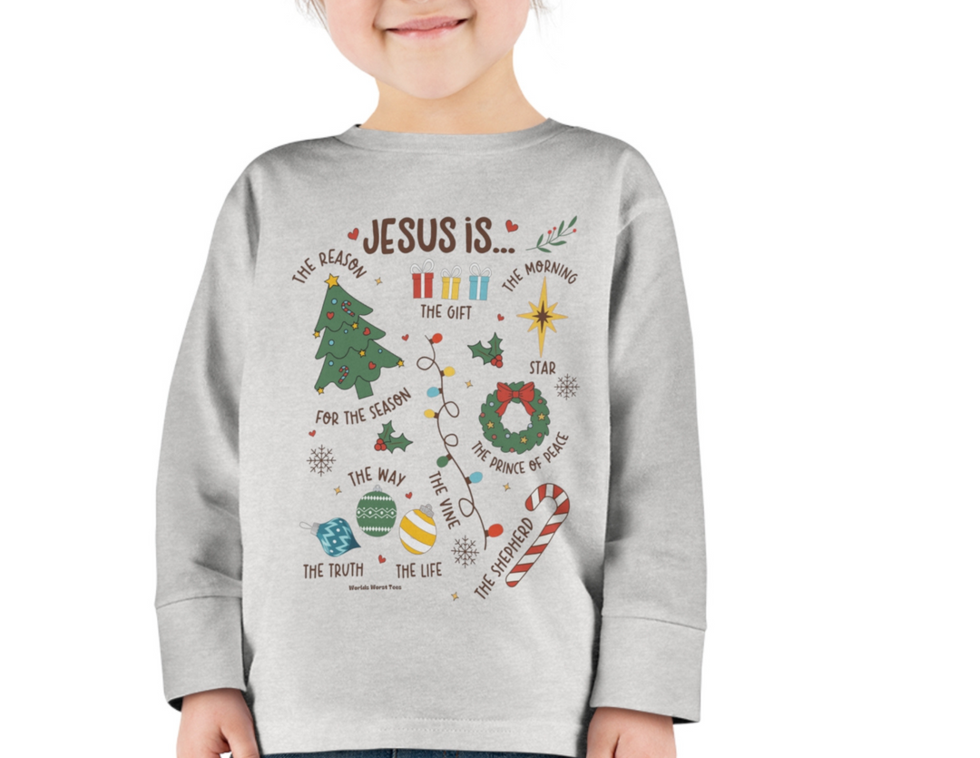 A toddler long-sleeve tee featuring a girl smiling, a sweatshirt with words, a Christmas tree drawing, and festive ornaments. Made of 100% cotton, with ribbed collar and EasyTear™ label for comfort and durability.