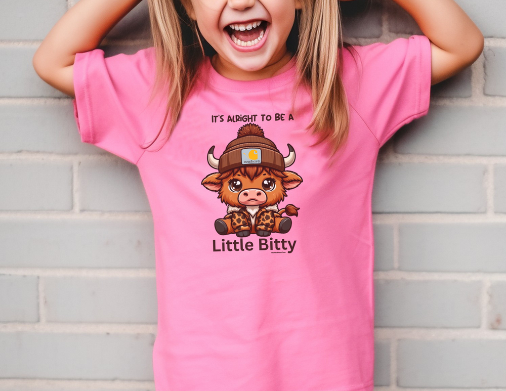 Little Bitty Kids Tee: A girl in a pink shirt smiles, showcasing this active shirt. 100% combed ringspun cotton for comfort and agility. XS-XL sizes. Ideal for play or study time.