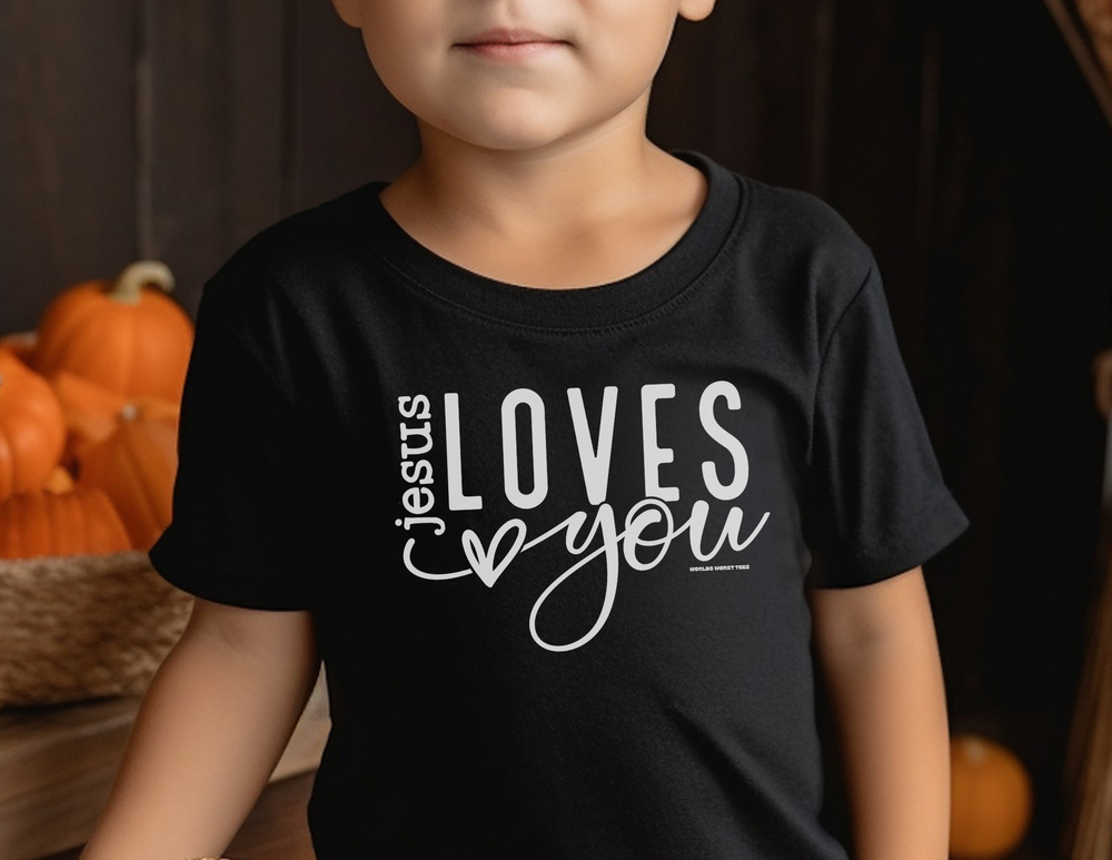 A black tee for toddlers with Jesus Loves You print. Soft, 100% combed ringspun cotton, light fabric, tear-away label, classic fit. Perfect for sensitive skin, ideal for first adventures.