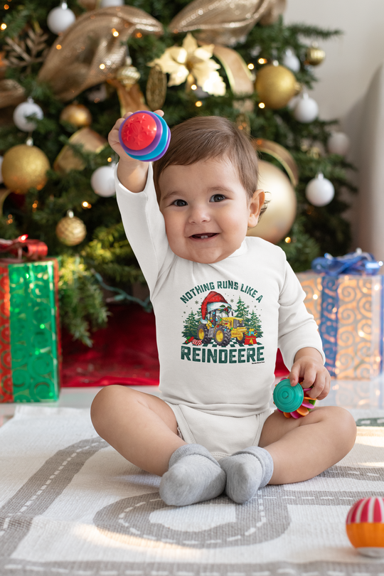 A baby in a Christmas-themed long sleeve bodysuit, featuring a reindeer design. Made of soft cotton, with plastic snaps for easy changing. From Worlds Worst Tees.