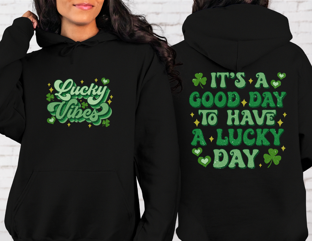 Woman wearing the Good Day Lucky Day Hoodie, a black sweatshirt with green text. Unisex hoodie made from cotton-polyester blend, featuring a kangaroo pocket and matching drawstring.