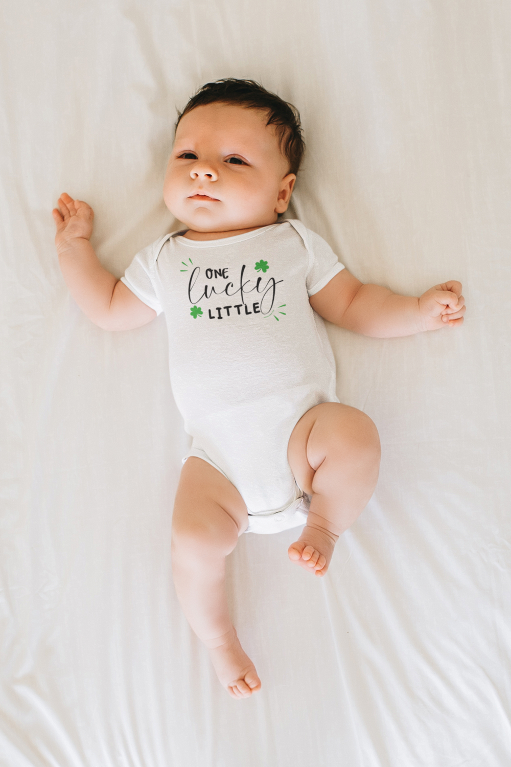 A baby bodysuit featuring One Lucky Little design. 100% cotton fabric, ribbed knitting for durability, plastic snaps for easy changing. Infant fine jersey, light fabric, tear away label.