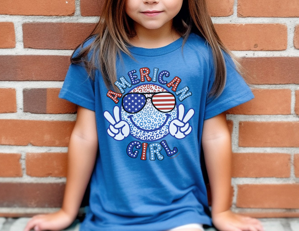 A toddler tee featuring a girl in a blue shirt with sunglasses, ideal for sensitive skin. Made of 100% combed ringspun cotton, light fabric, tear-away label, and a classic fit. Sizes: 2T, 3T, 4T, 5-6T.