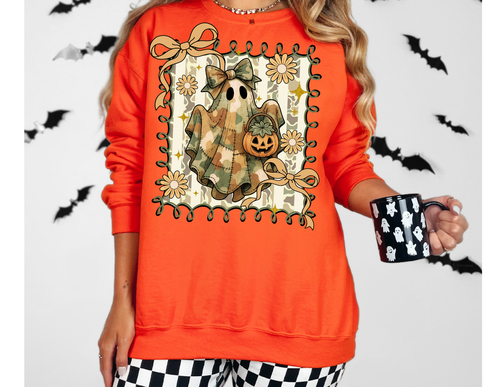 Person wearing the Quilted Ghost Crew sweatshirt, featuring a camo-patterned ghost with a bow and jack-o’-lantern, framed by flowers and sparkles, holding a ghost-patterned mug.