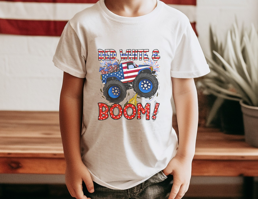 A boy in a white Red White and Boom Kids Tee with a truck design, embodying comfort and agility for active kids. Made of soft-washed, garment-dyed cotton for all-day wear. Classic fit for study or play.