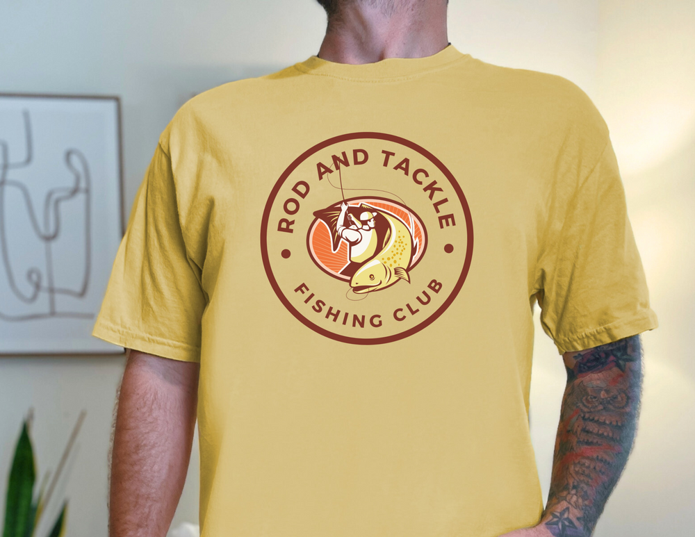 A premium Rod and Tackle Fishing Club Tee for men, featuring a man in a yellow shirt fishing. Comfy, light, 100% cotton, with a high-quality print for workouts or daily wear.