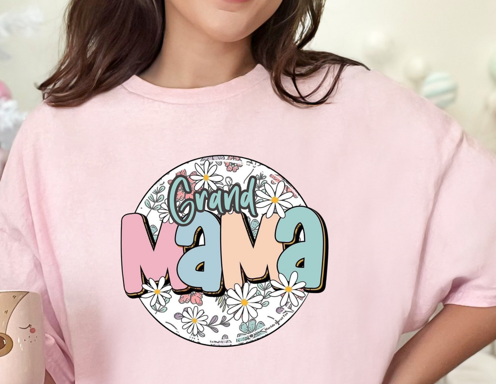 A woman in a pink Sassy Grand Mama Flower Tee, featuring a vibrant floral design. Unisex heavy cotton tee with ribbed knit collar, classic fit, and durable construction. Ideal for casual fashion.