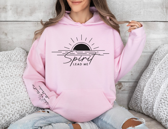 A woman wearing a Spirit Lead Me Hoodie, a cozy unisex blend of cotton and polyester. Features a kangaroo pocket and matching drawstring hood for style and practicality. Ideal for chilly days.