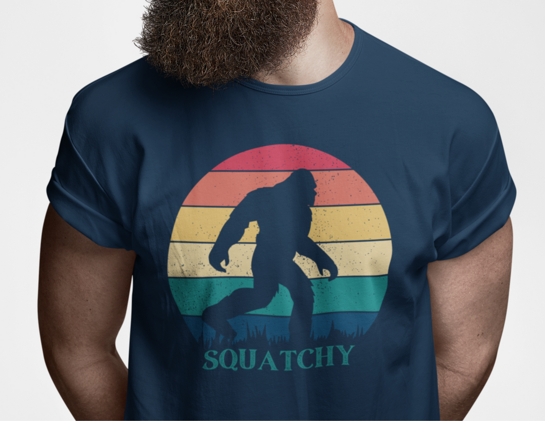 A fitted Squatchy Tee for men, featuring a bigfoot graphic. Combed cotton, ribbed collar, and side seams for structure. Ideal for workouts or daily wear. From Worlds Worst Tees.