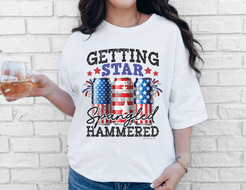 A relaxed fit Star Spangled Hammered Tee in white, 100% ring-spun cotton. Garment-dyed for coziness, with double-needle stitching for durability and no side-seams for a tubular shape.