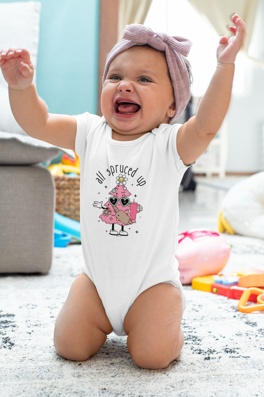A baby wearing an All Spruced up Onesie, a durable infant long sleeve bodysuit with plastic snaps for easy changing. Made of 100% cotton for softness.
