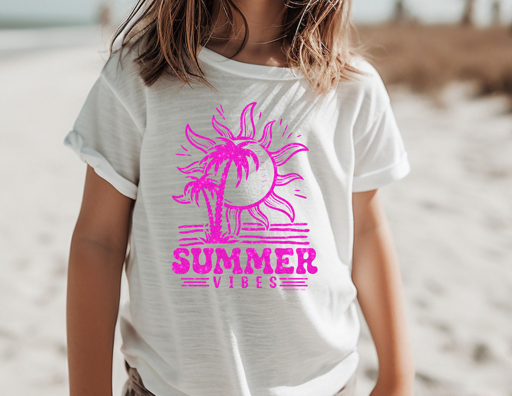 A kid's tee featuring a white shirt with pink sun and palm trees, ideal for active days. Crafted from 100% soft combed cotton for comfort during play or study. Classic fit for all-day wear.