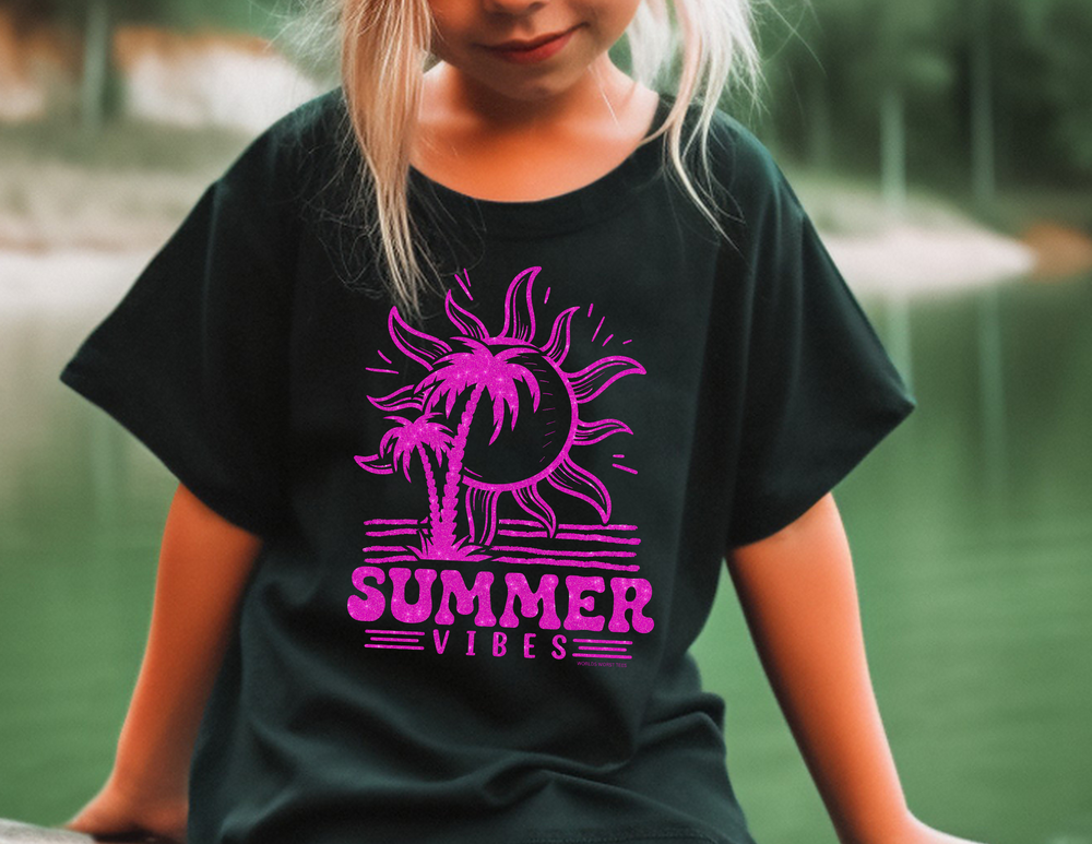 A toddler wearing a Summer Vibes Toddler Tee, featuring a girl in a black shirt. Soft, 100% cotton fabric with a durable print, perfect for little adventures. Sizes from 2T to 5-6T.