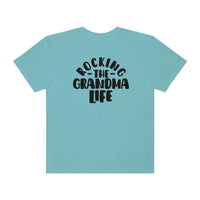 Rocking the Grandma Life Tee: A blue shirt with black text, 100% ring-spun cotton, medium weight, relaxed fit, double-needle stitching for durability, and seamless design for a tubular shape.