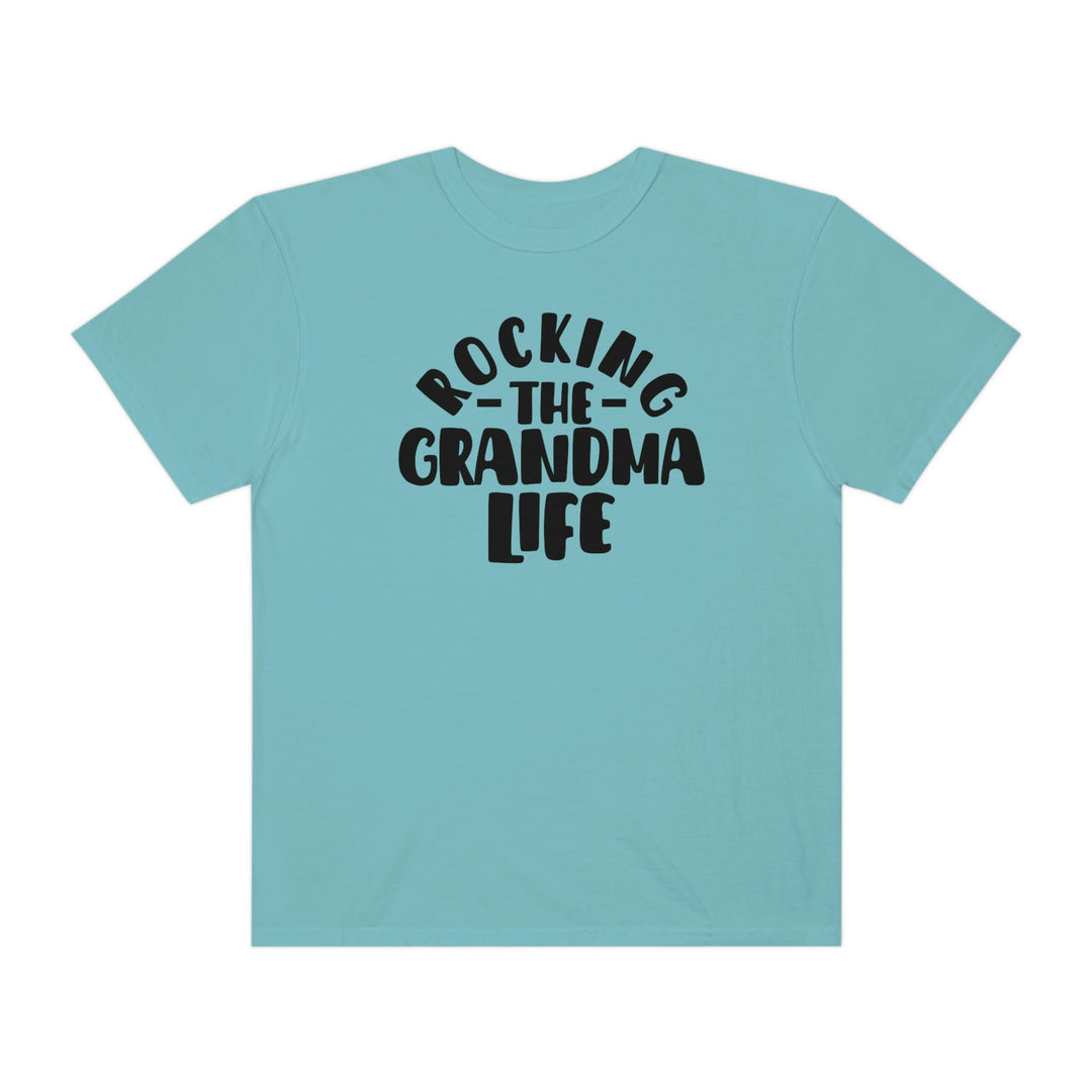 Rocking the Grandma Life Tee: A blue shirt with black text, 100% ring-spun cotton, medium weight, relaxed fit, double-needle stitching for durability, and seamless design for a tubular shape.