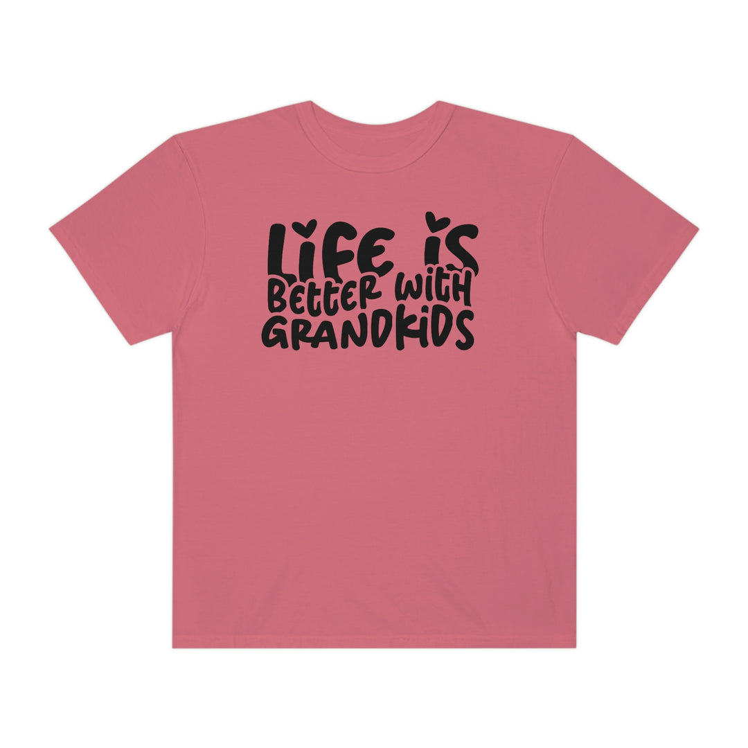 A ring-spun cotton Life is Better With Grandkids Tee in pink with black text. Garment-dyed for extra coziness, featuring a relaxed fit and durable double-needle stitching. Ideal for daily wear.
