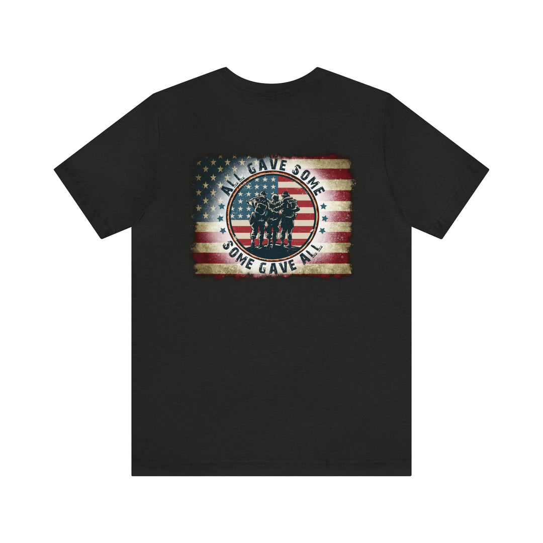 USA Some Gave All Tee: Black shirt featuring soldiers in a circle with a flag. Unisex jersey tee with ribbed knit collars, taping on shoulders, and dual side seams for durability. 100% cotton, retail fit.