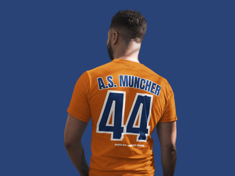 A relaxed fit Houston Asshats #44 A.S. Muncher Tee in orange with blue text and numbers. Made of 100% ring-spun cotton, garment-dyed for extra coziness and durability. No side-seams for a tubular shape.