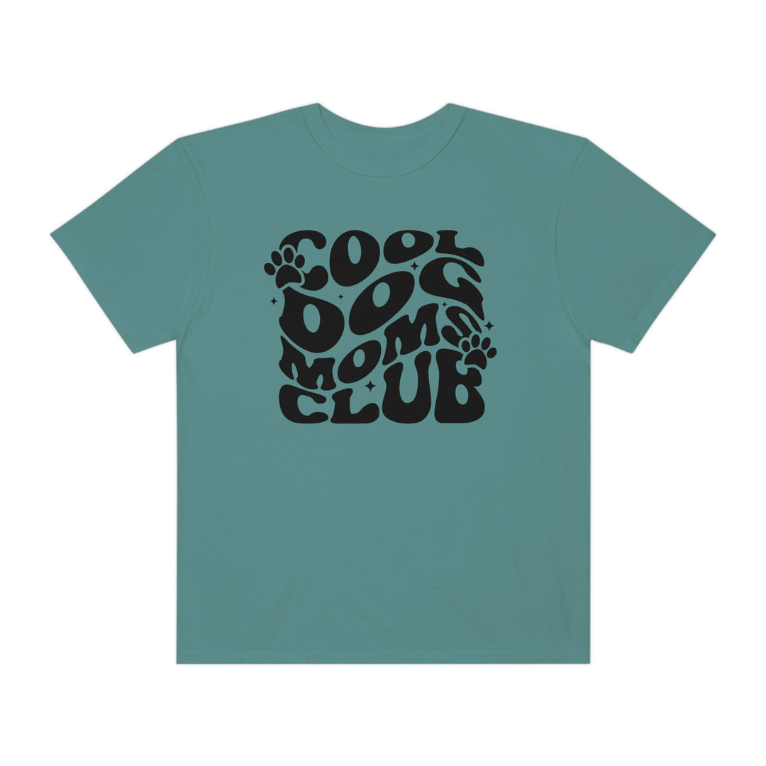 Cool Dog Mom's Club Tee: A black t-shirt featuring a blue logo and paw print design. Made of 100% ring-spun cotton with a relaxed fit for everyday comfort. Durable double-needle stitching and seamless sides.