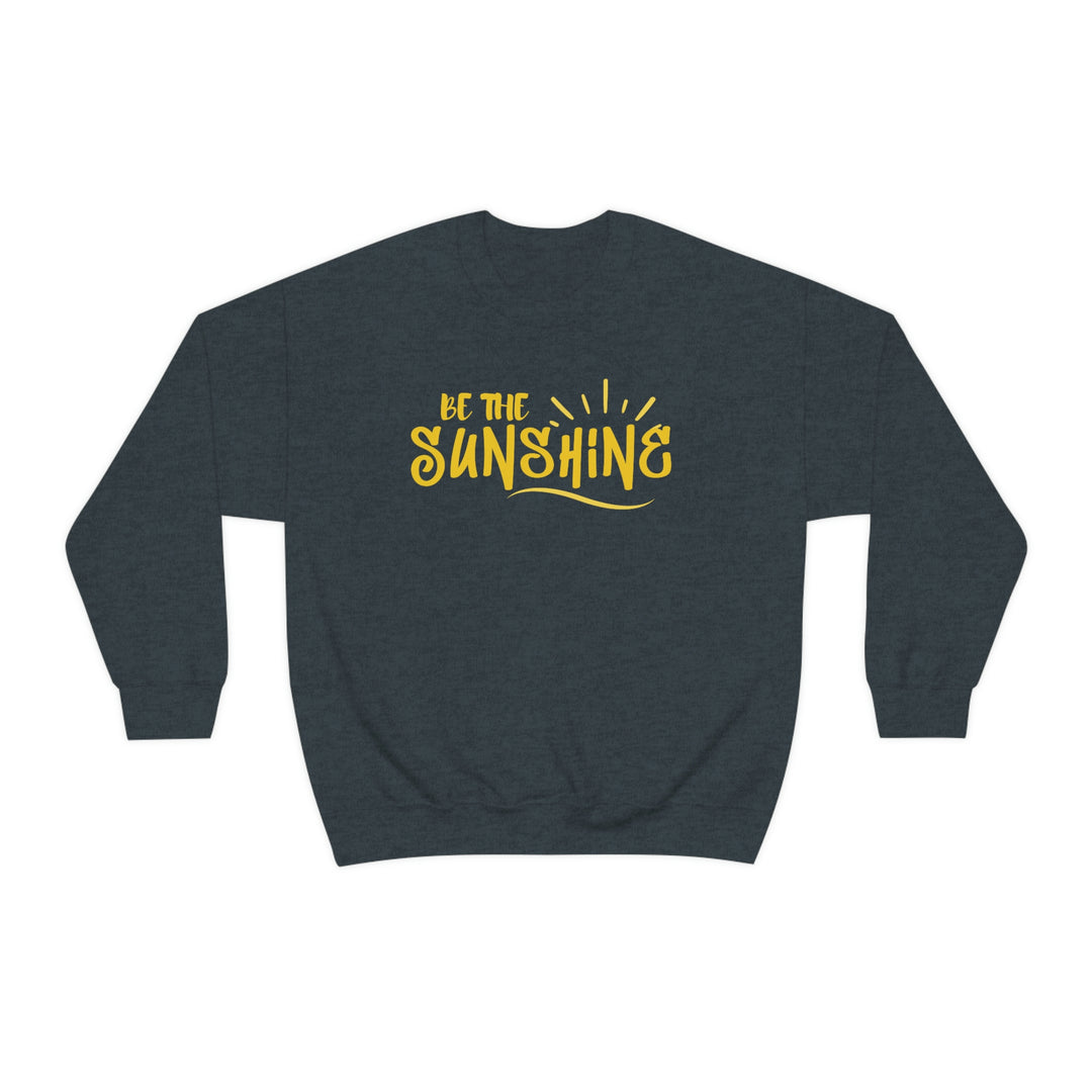 A unisex heavy blend crewneck sweatshirt featuring Be The Sunshine text. Made of 50% cotton and 50% polyester, with a ribbed knit collar and a loose fit. Sewn-in label, true to size.