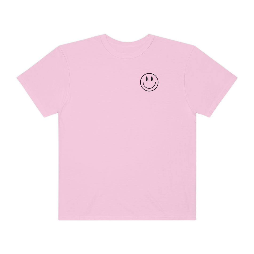 A relaxed-fit pink t-shirt featuring a black smiley face design. Made of 100% ring-spun cotton for coziness and durability. Ideal for daily wear with double-needle stitching and no side-seams.