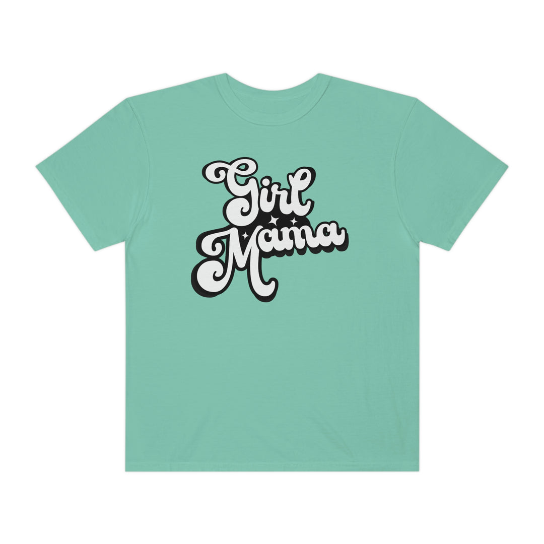 Girl Mama Tee: A green shirt with white text featuring a black and white cartoon character. 100% ring-spun cotton, garment-dyed for extra coziness, with a relaxed fit and durable double-needle stitching.