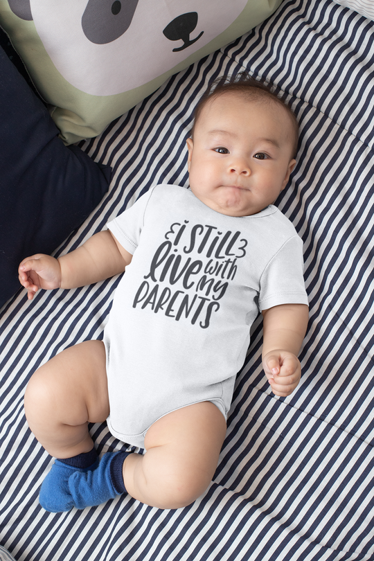 A humorous and cozy infant bodysuit titled I Still Live With My Parents Onesie from Worlds Worst Tees. Features durable 100% cotton fabric, ribbed bindings, and convenient plastic snaps for easy changing.